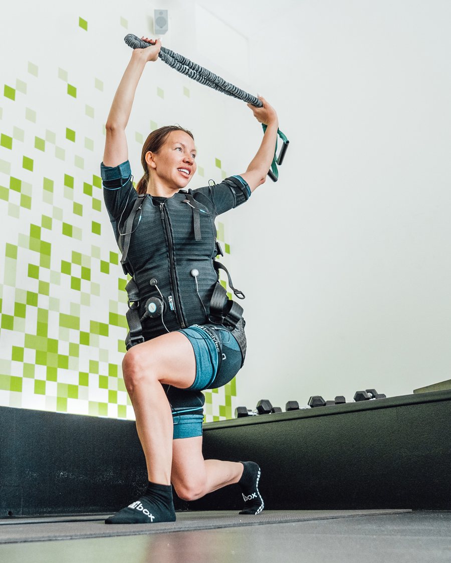 Frau beim Ausfallschritt mit Trainingsband im EMS-Training