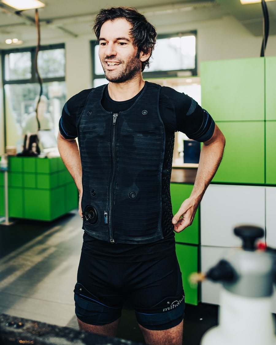 Lächelnder Mann im EMS-Anzug im fitbox Studio